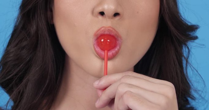Asian beautiful woman tasting candy sweet and happy emotion smile. beautiful woman feeling sweet sugar. Concept of beauty, food, fashion, travel and shopping.
