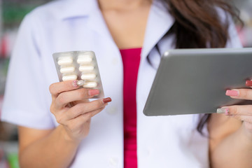 The pharmacist holds medicine box of medicine in the pharmacy