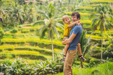 Naklejka na ściany i meble Dad and son travelers on Beautiful Rice Terraces against the background of famous volcanoes in Bali, Indonesia Traveling with children concept