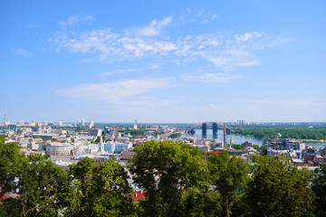 View through the green foliage of the city from above. Panorama.