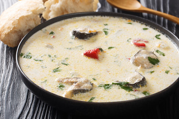 Delicious creamy fish soup with eel, cheese and vegetables close-up in a bowl. horizontal
