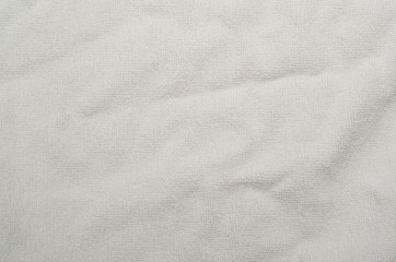 Fototapeta na wymiar Wrinkled white towel background. texture of bright white bath towel