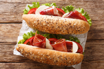 Mediterranean sandwiches with jamon, mozzarella cheese, tomatoes and leaf lettuce close-up....