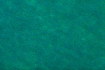 Green background of felt fabric. Texture of woolen textile.