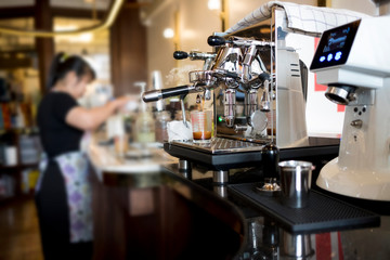Fototapeta na wymiar Close-up of Coffee machine Barista woman making coffee on the background blurry.
