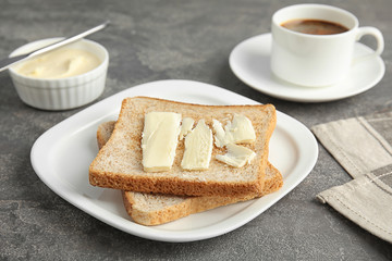 Bread with butter served for breakfast on grey table