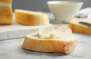 Slice of bread with butter on marble table