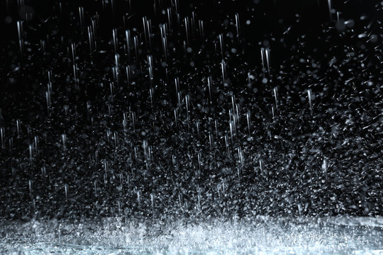 Heavy Rain Falling Down On Ground Against Dark Background