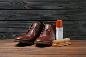 Leather footwear and shoe shine kit on wooden surface