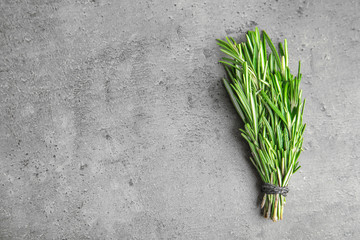 Bunch of fresh rosemary on grey table, top view with space for text