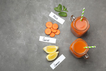 Flat lay composition with carrot juice and different ingredients on grey table, space for text
