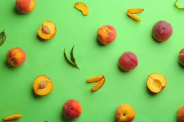 Flat lay composition with fresh peaches on green background