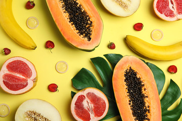 Flat lay composition with condoms and exotic fruits on yellow background. Erotic concept
