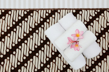 towels on batik cover bed