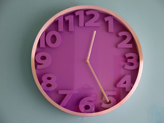 Purple wall clock on blue background