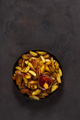 Fried potatoes with  brava sauce on a dark background with copy space top view