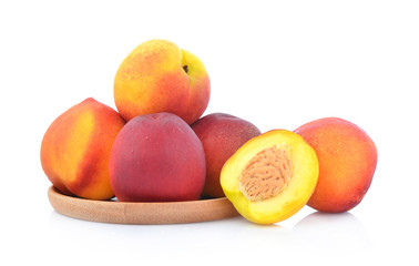 Peachs in wooden dish isolated on white background