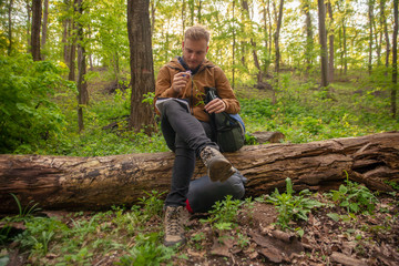 one young man, analyzing a flower in forest.