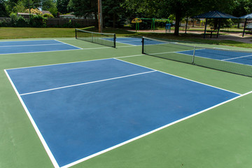Recreational sport of pickleball court in Michigan, USA looking at an empty blue and green new court at a outdoor park.