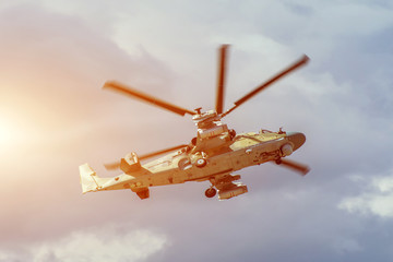 Fototapeta na wymiar Military combat helicopter flies rapidly turning in the air.