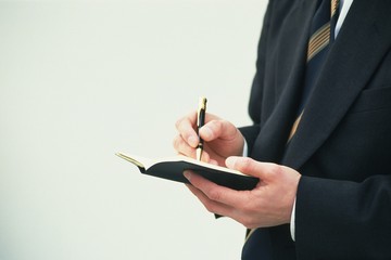businessman writing on agenda