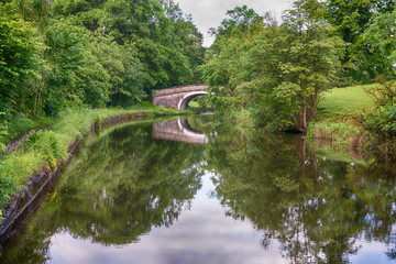 View of a British canal in rural setting with stone bridge