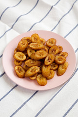 Homemade fried plantains on a pink plate, side view. Close-up.