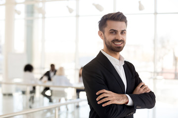 Portrait smiling employee look at camera in company office hallway