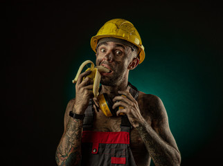 Portrait of a happy smiling miner eating a banana for lunch