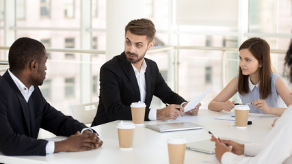 Interested colleagues listen to employee talk at company meeting