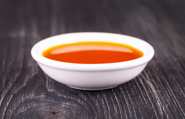 The sea buckthorn oil in the white small Cup on old wooden background