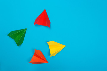 Color paper airplanes on blue background.