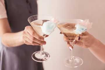 Women clinking glasses with cotton candy cocktail at party