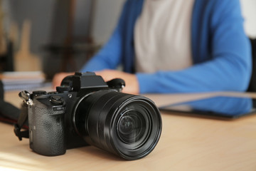 Modern photo camera on table