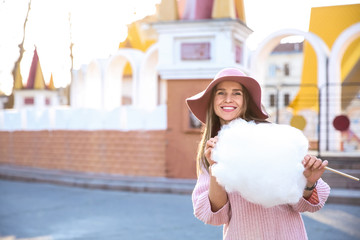 Woman with sweet cotton candy outdoors