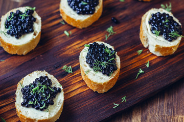 Appetizer for christmas table - black caviar on the pieces of bread.