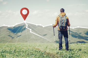 Hiker man standing in front of route with location GPS pin on peak of mountain ridge.