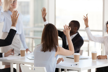 Rear view, employees involved in team building activity, raised hands