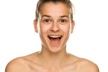 Portrait of young smiling woman without makeup on white background