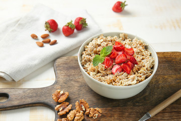 Bowl with tasty sweet oatmeal on table