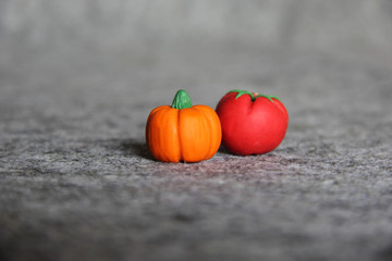 Close up handmade polymer clay miniature of pumpkin and tomato