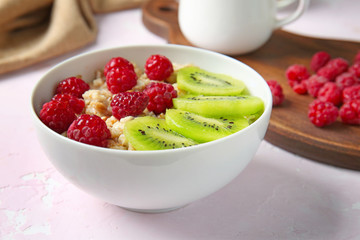 Bowl with tasty sweet oatmeal on light table