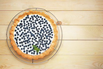 Tasty bilberry pie on wooden background