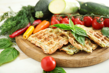 Board with tasty squash waffles on table, closeup