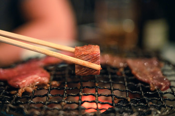 Grilled raw beef slice on flaming grill