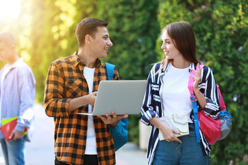 Naklejka premium Young students with laptop outdoors