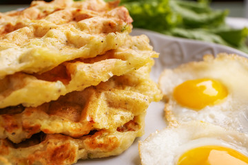 Tasty squash waffles and fried quail eggs on plate, closeup