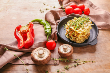 Composition with tasty squash waffles and vegetables on wooden background