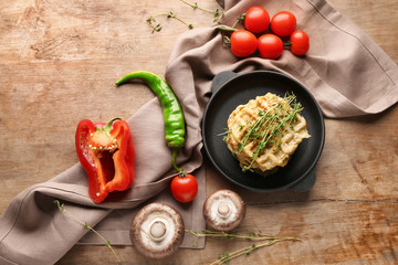 Composition with tasty squash waffles and vegetables on wooden background