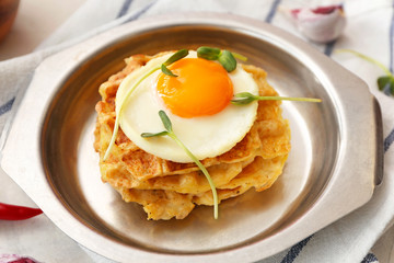 Plate with tasty squash waffles and fried egg on table, closeup